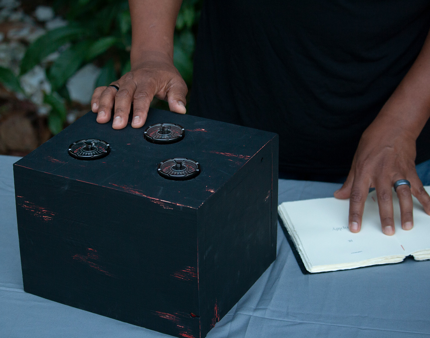 User reviews the dials on the wooden box and consults the messages in the code book