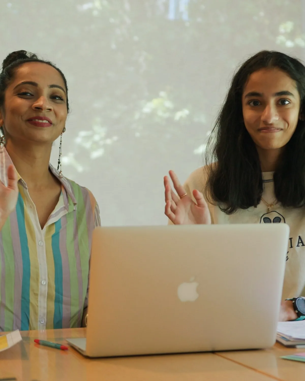 Amrita and her mum smiling and waving to her tutor at the start of a maths lesson