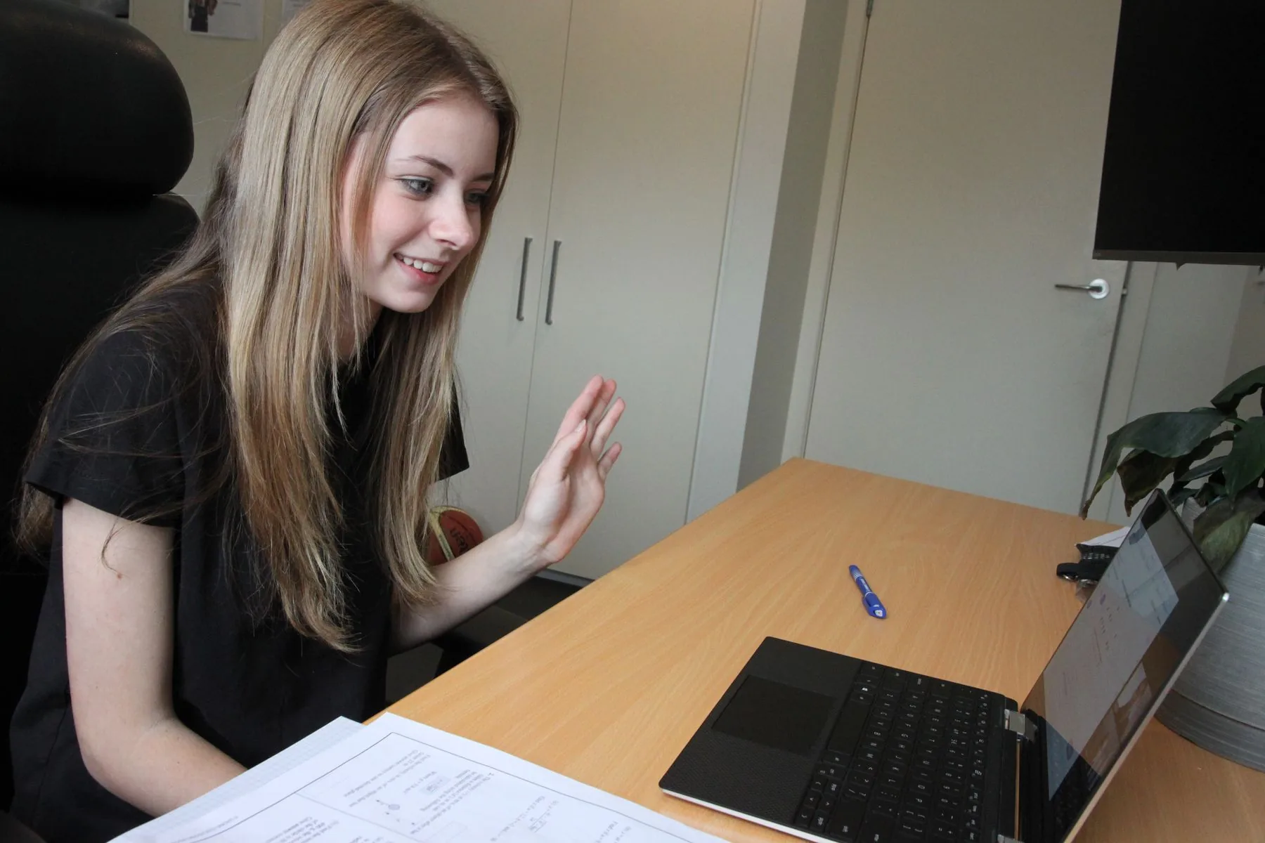 Student waving to her tutor at the start of an online lesson