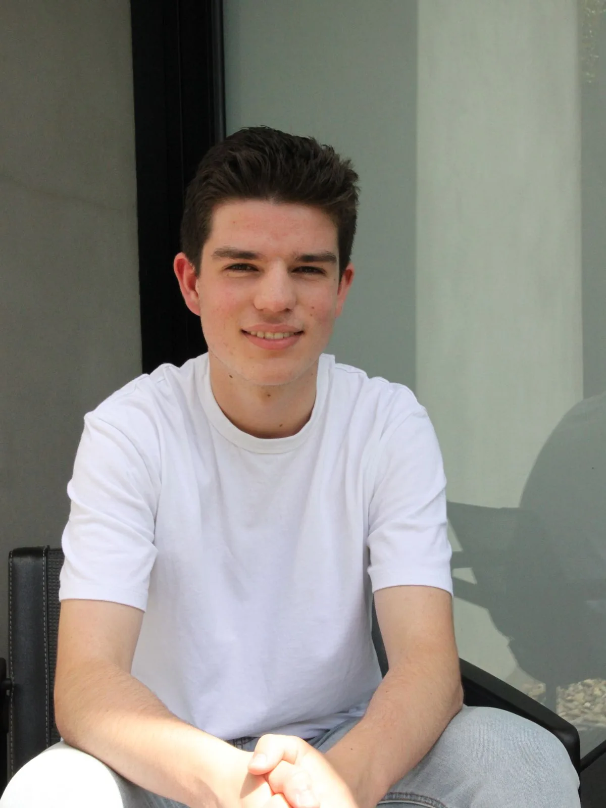 Senior student smiling in his study at home