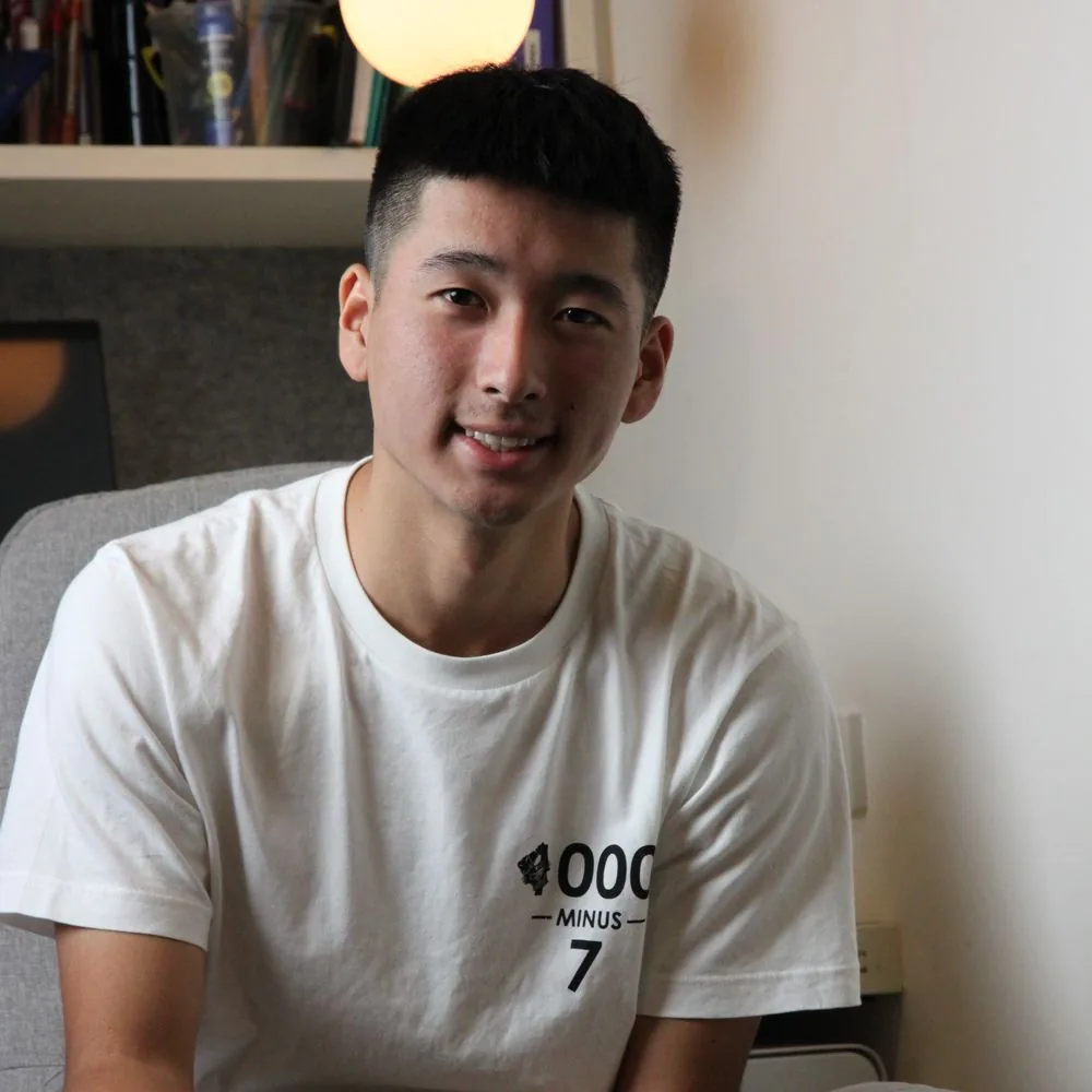Senior student smiling at his desk at home