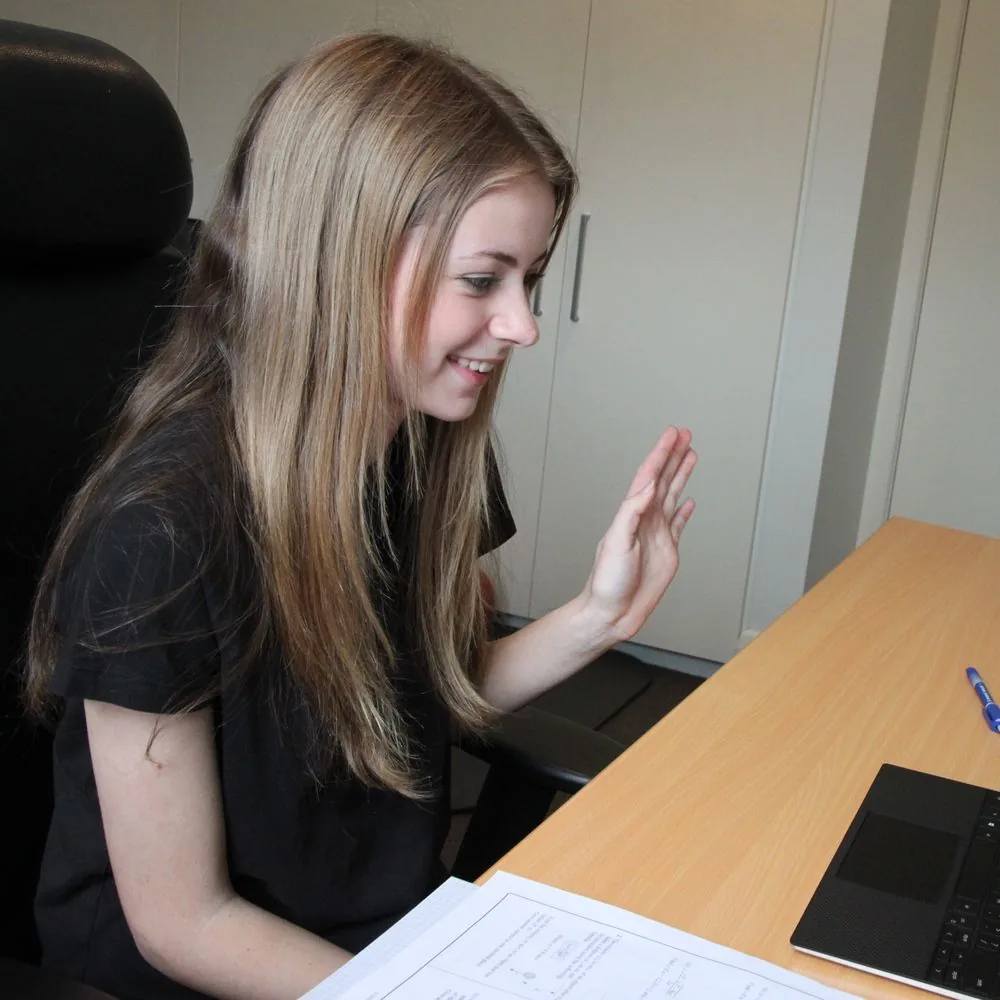 Senior student waving to her tutor at the start of an online lesson