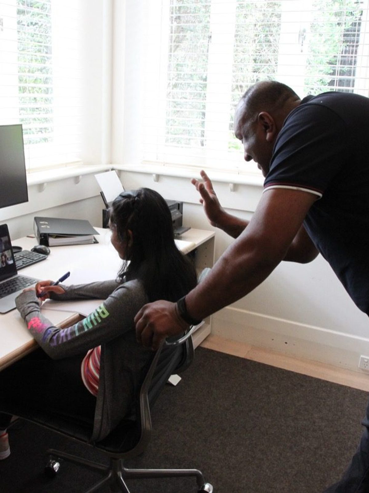 Parent checking in during his daughter's online lesson at home
