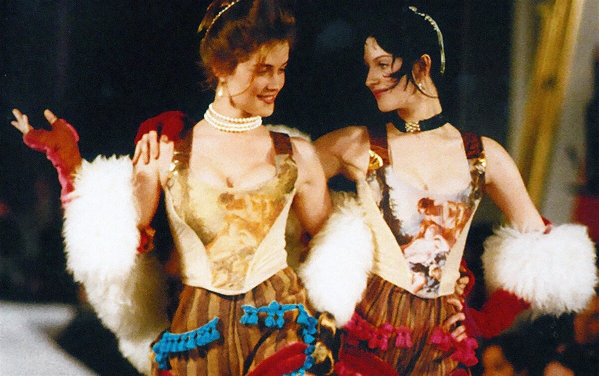 Two models wearing flashy corsets.