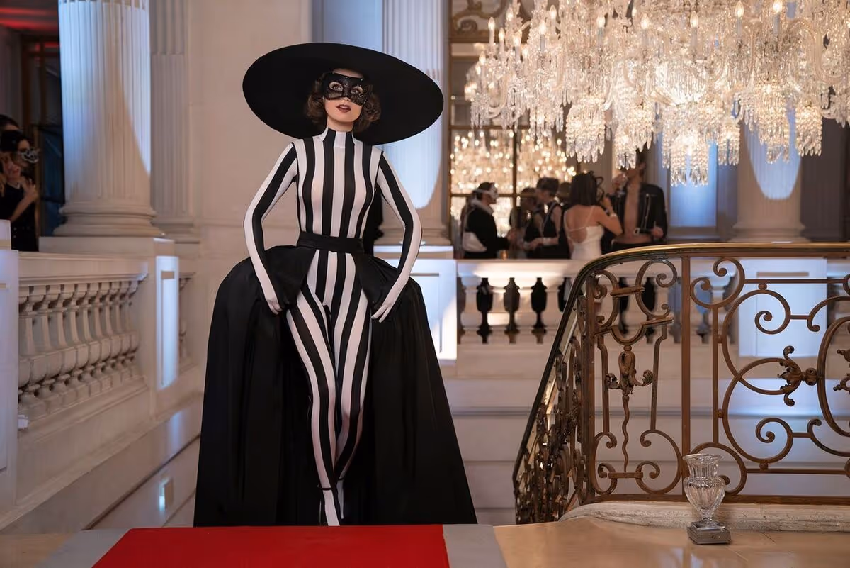 A still from Emily in Paris, depicting the titular character in a black-and-white catsuit-gown hybrid.