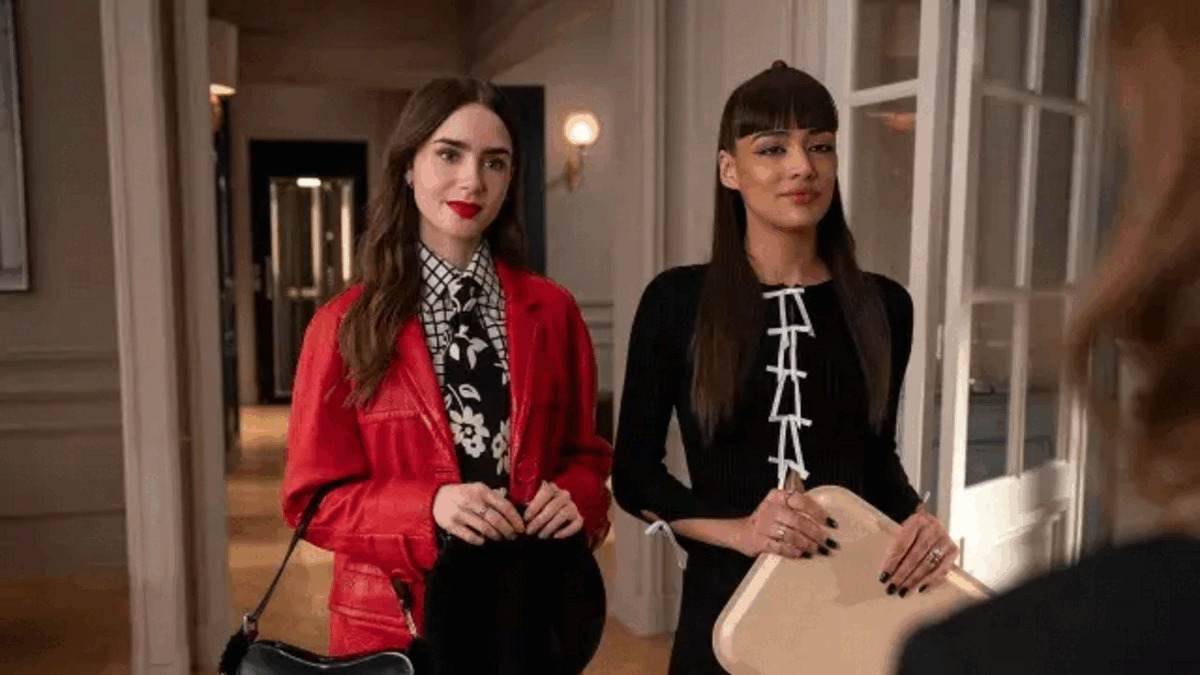 “Emily in Paris” protagonist Emily Cooper in a red jacket over a black-and-white top and tie.
