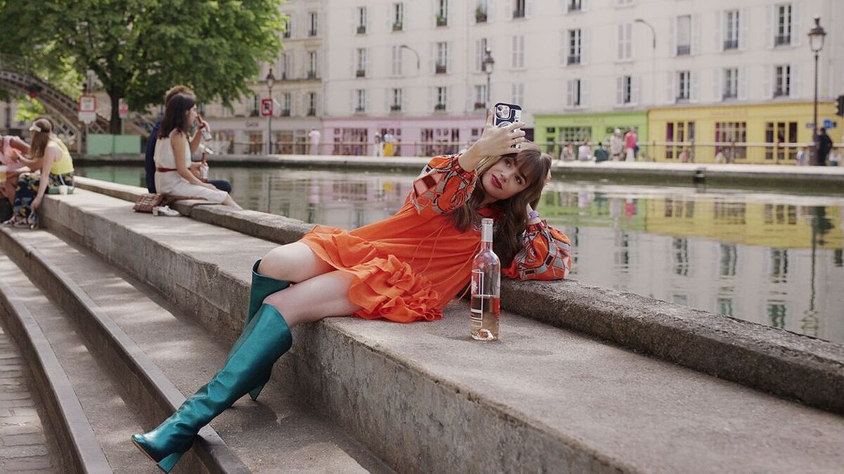 Emily in Paris protagonist Emily Cooper in an orange dress and turquoise boots.