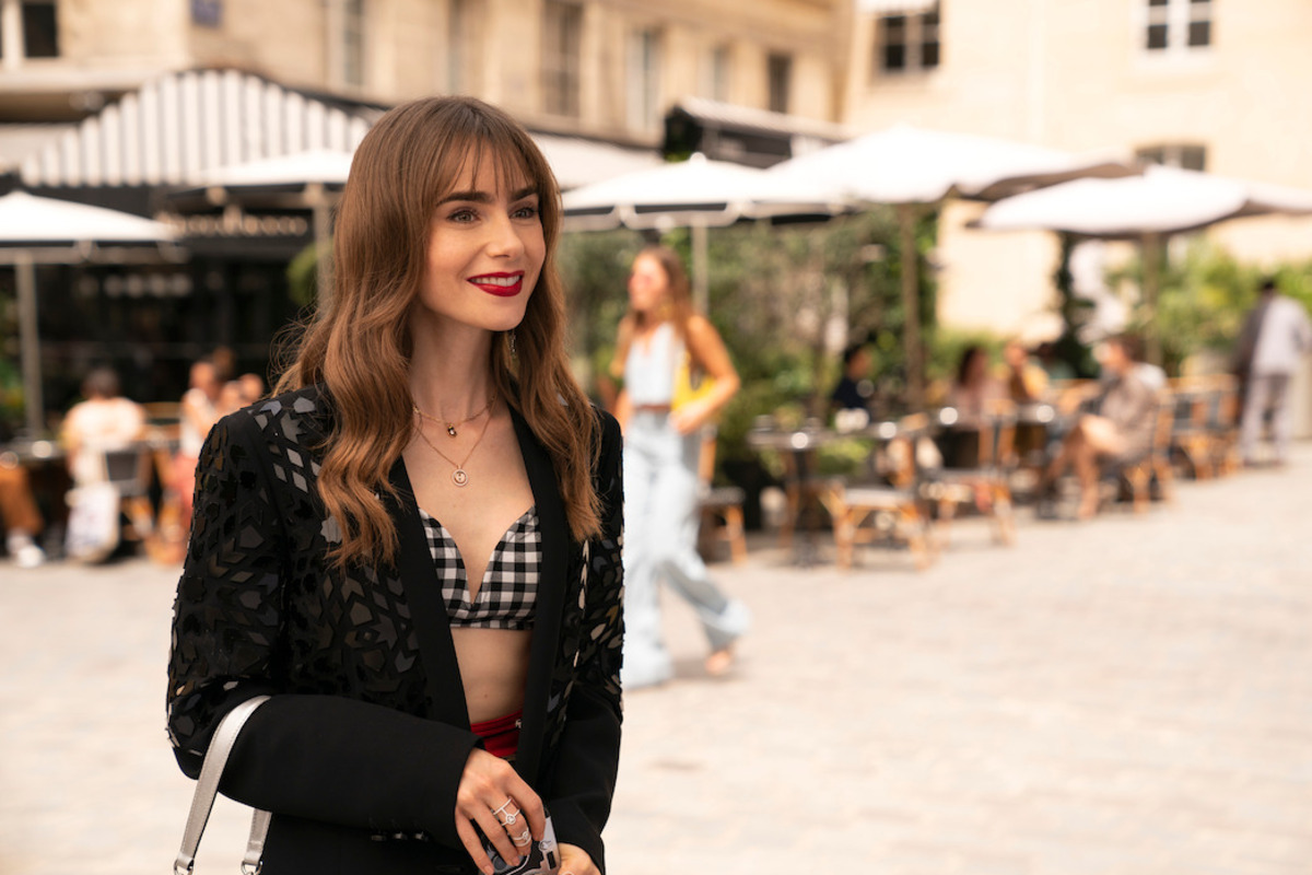 “Emily in Paris” protagonist Emily Cooper in a check print top and a black jacket.