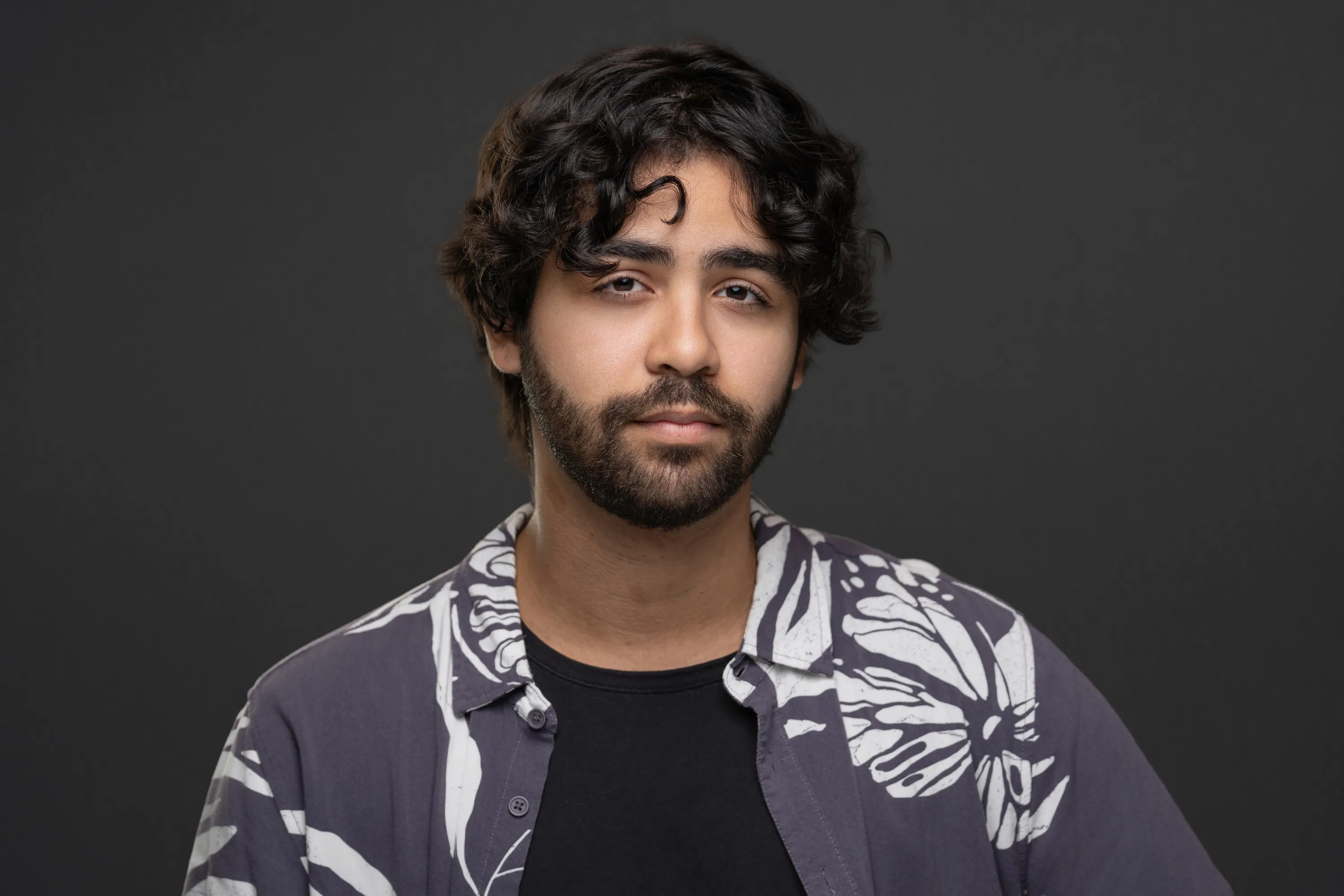 A younger man posing for an acting headshot professionally lit