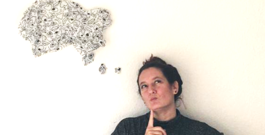 Tina posing with a paper thinking bubble on the wall