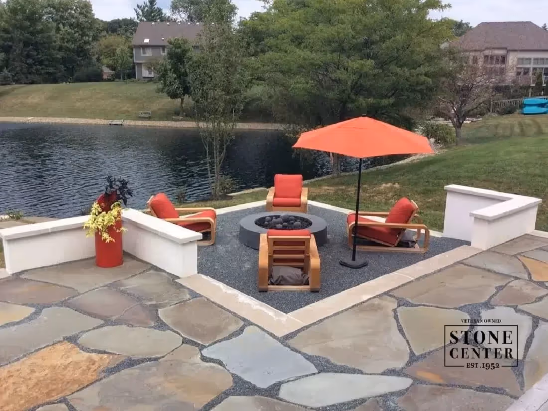 patio with stone firepit and natural pond in the background