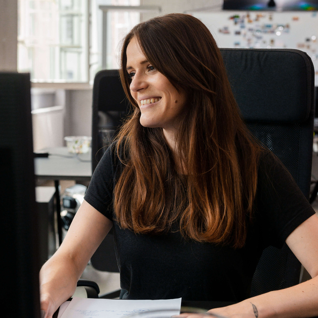 A smiling woman sitting at her desk at work