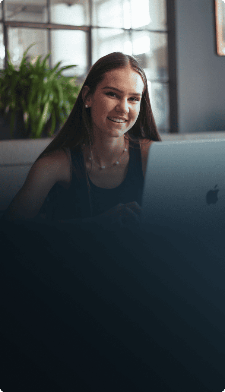 Junge, zufriedene Studentin mit langen Haaren lernt mit der simpleclub App an ihrem Computer.