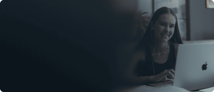 Junge, zufriedene Studentin mit langen Haaren lernt mit der simpleclub App an ihrem Computer.