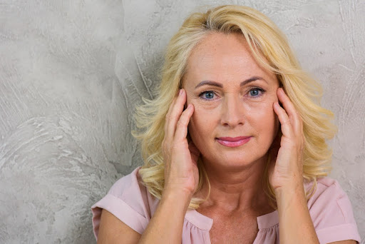 old woman applying ferulic acid serum 