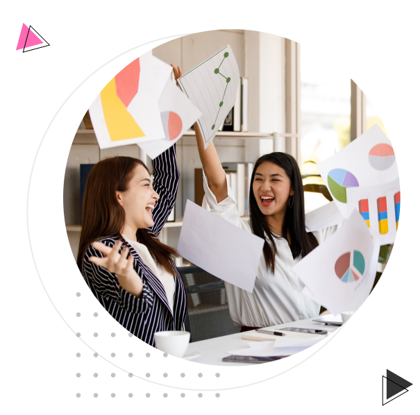 Mulheres felizes jogando papéis com gráficos para cima.