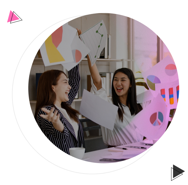 Mulheres felizes jogando papéis com gráficos para cima.