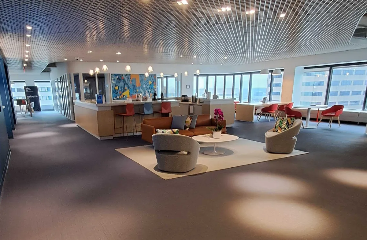 A large room with a blue carpet and a couch.