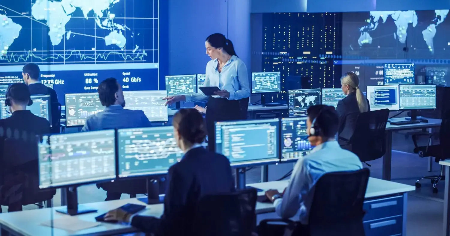 Cybersecurity team monitoring global networks on multiple screens in a high-tech control room.