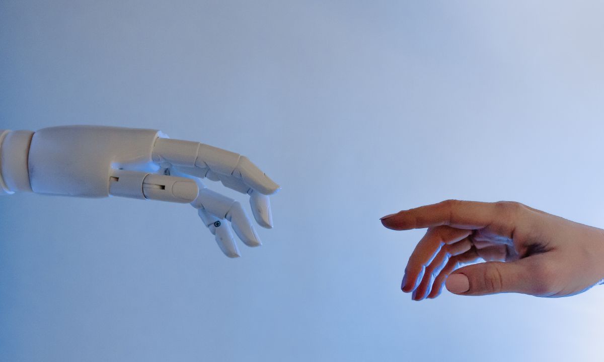 A human and robotic hand reach out to touch