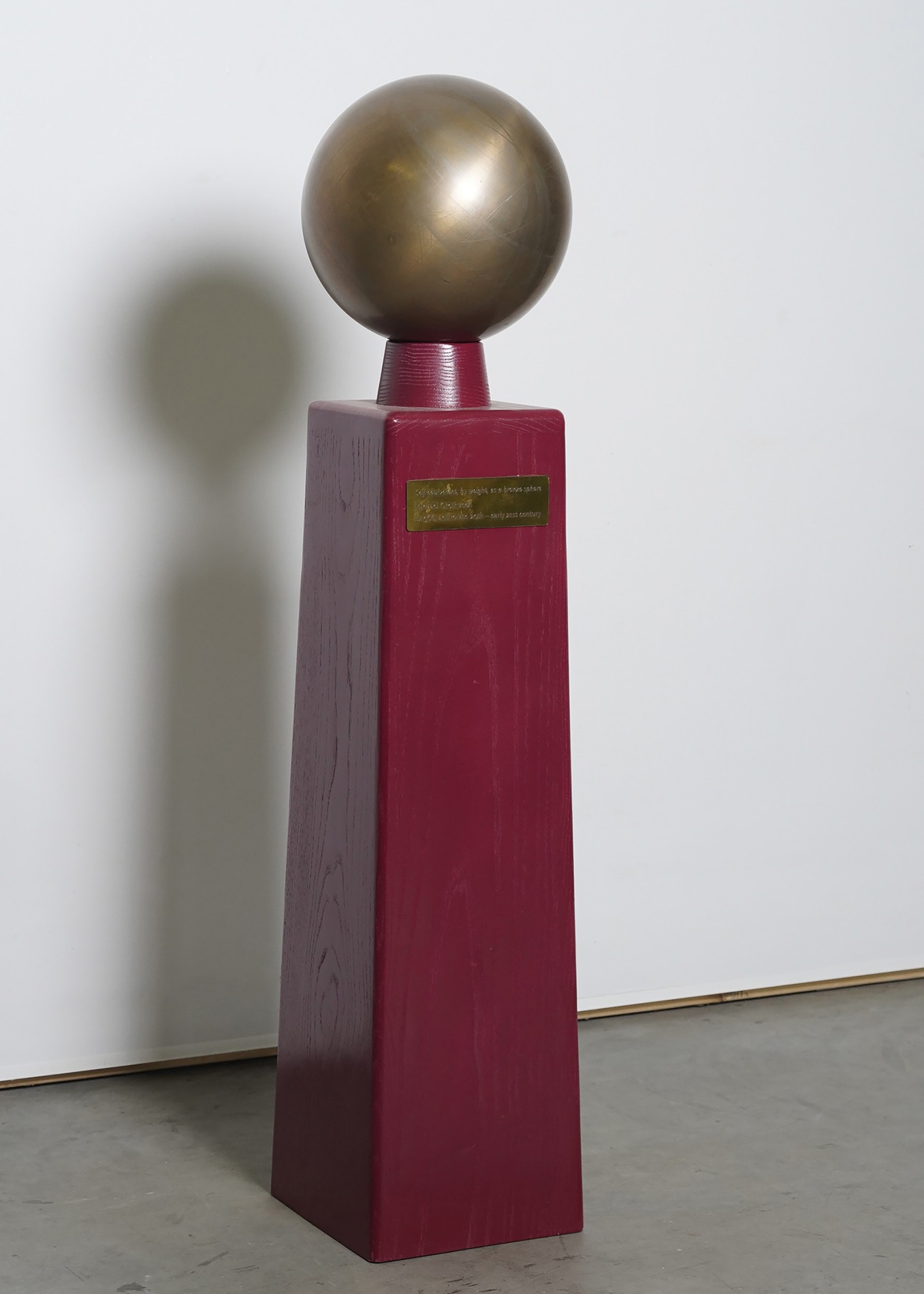 “Self Equivalent, by Weight” 44” x 10” x 10”. Consists of a solid bronze sphere that weighs the same as my body. Inspired by scientific instruments for weights and measures that are used as the standards by which all other things are weighed and measured.