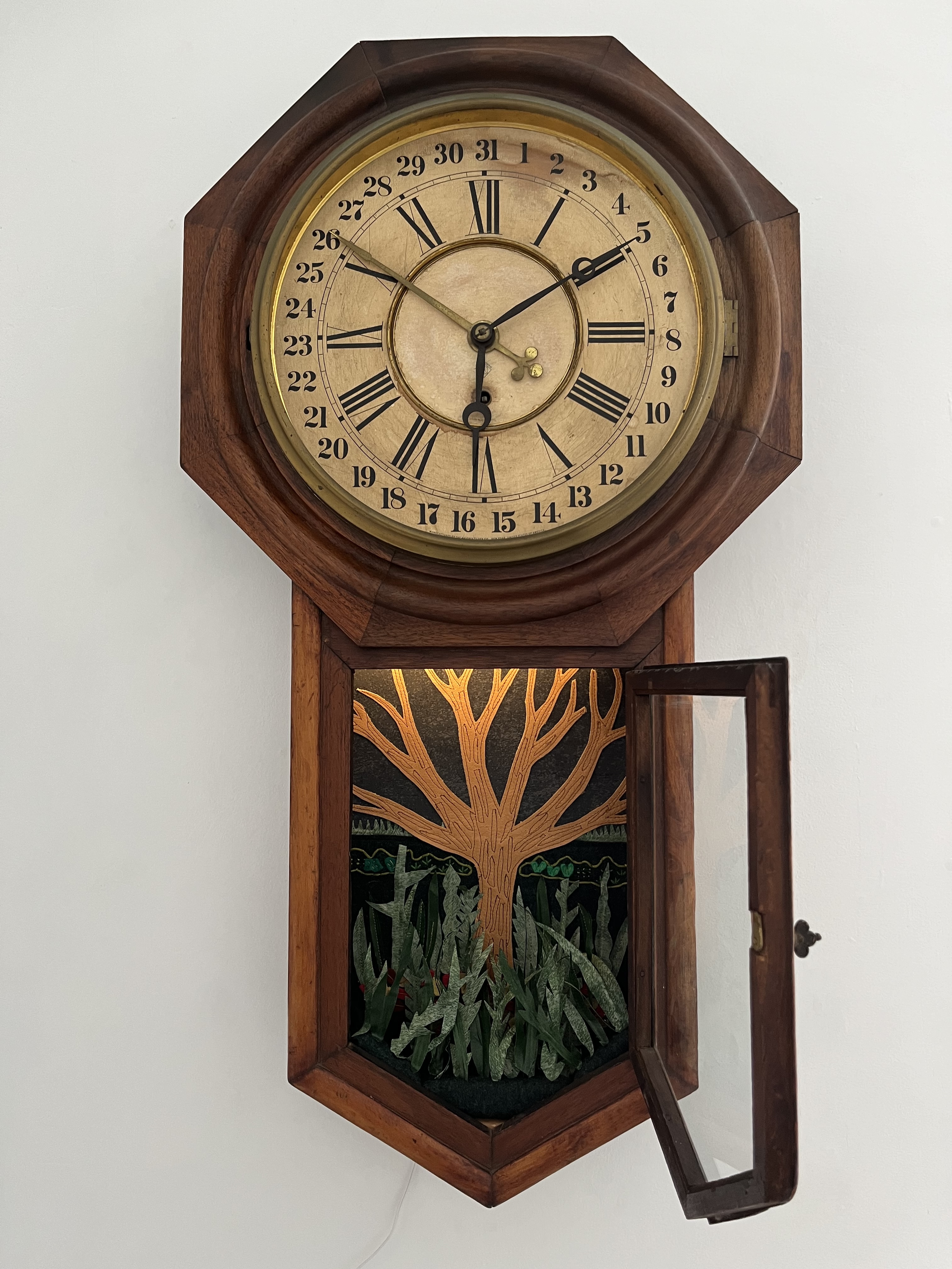 “We are in the weeds” Repurposed leather, vinyl, paper, lambwool, polyester, cotton, merino, silk, embroidery thread, antique clock, and internal lighting,  32" x 17" x 4"