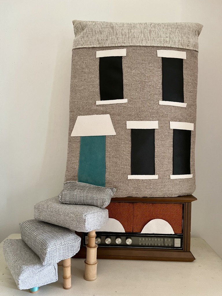 “House of Sound” Repurposed lambswool, suede, pleather, cotton, linen, foam, wooden rods, spools, thread, and vintage radio, 33" x 26" x 11"
