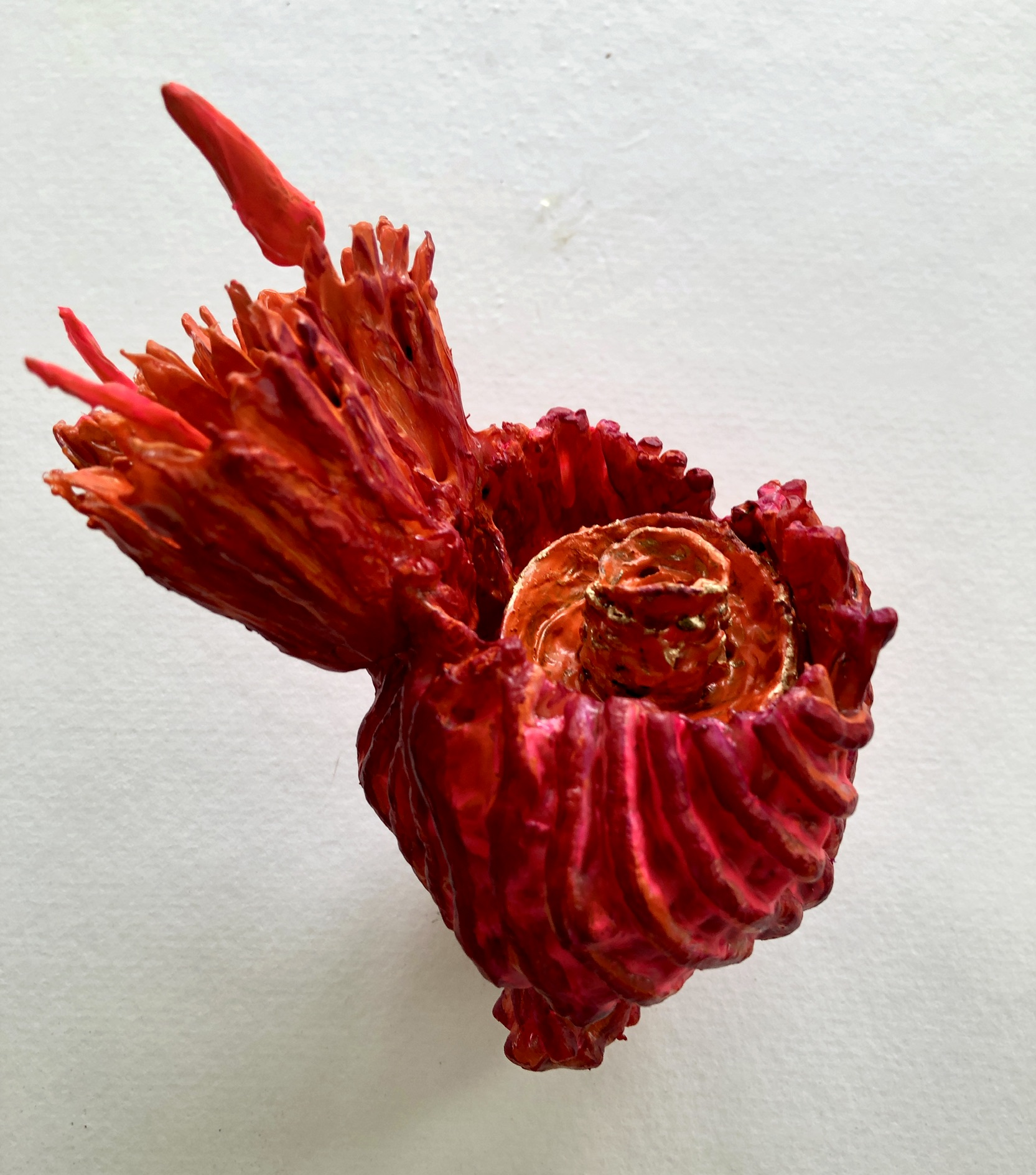 "Orange Centric Diatom" by Patti Dougherty,  Extruded packaging material, seed pod, acrylic paint. 6 x 6 x 5", 2025