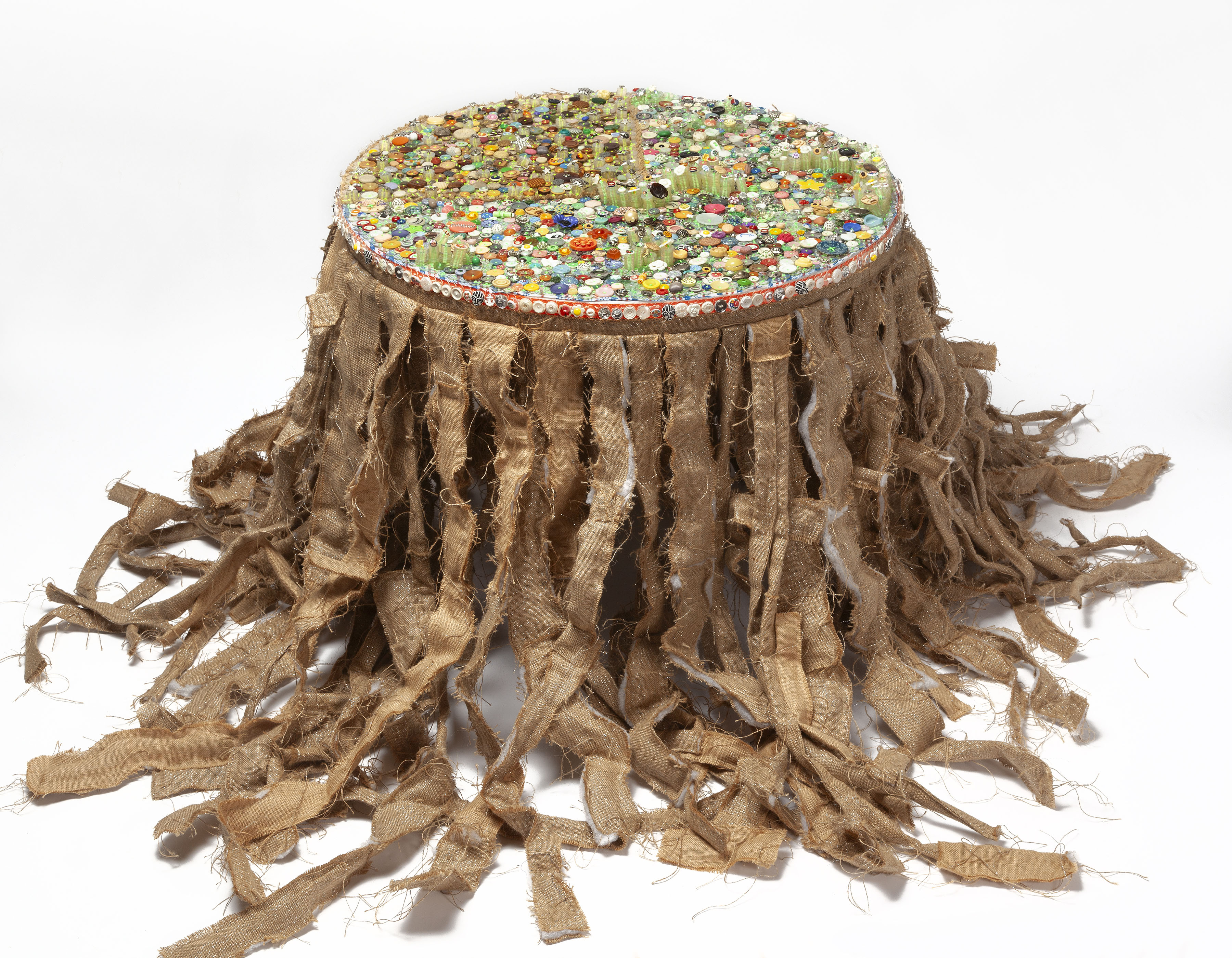The Conversation, 2017-2023, sculpture, assorted clothing buttons (cloth, metal, bone, et al.), embroidery thread, burlap, plastic bags, 34 x 36 in. diameter (table) total dimensions variable