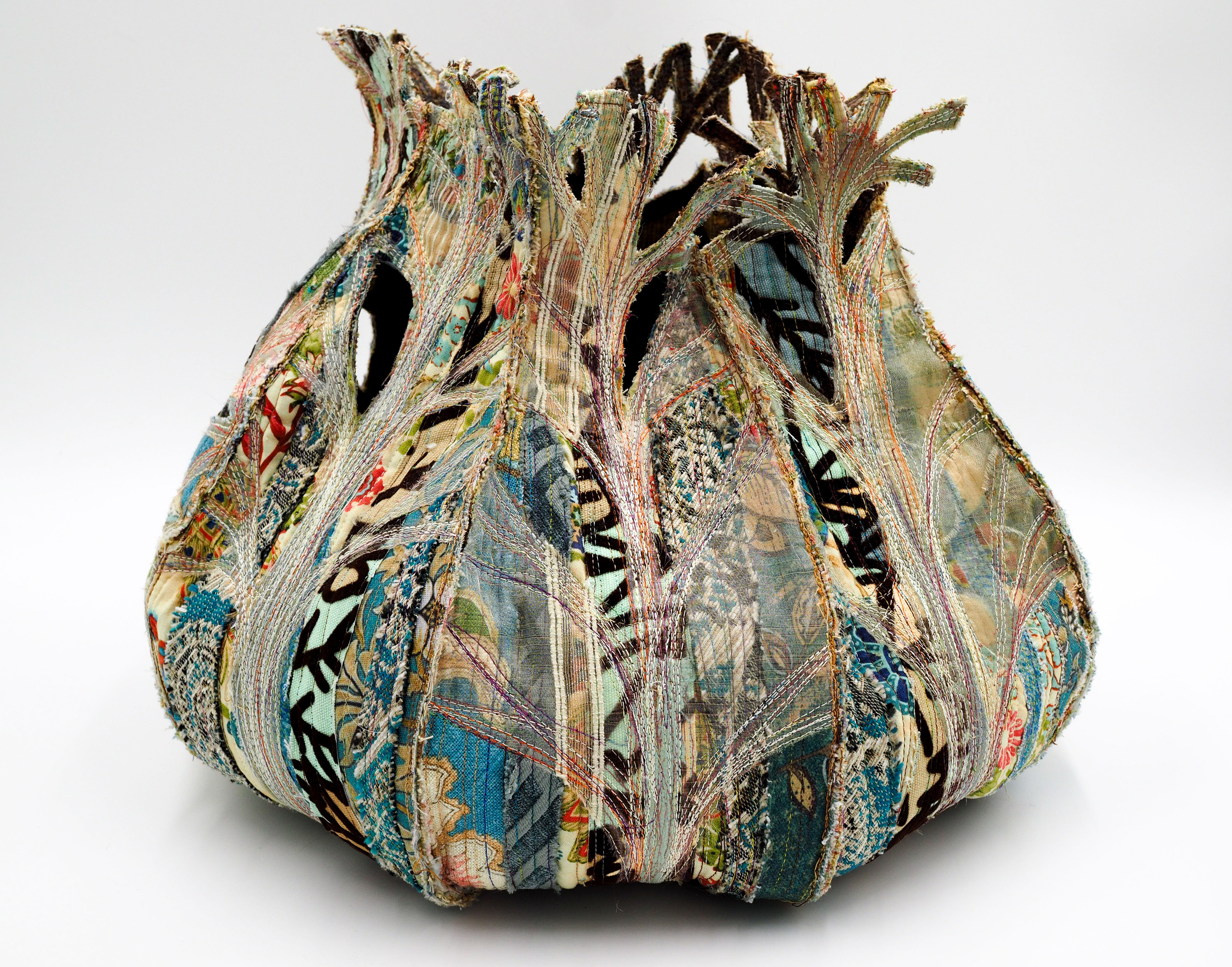 “Receptaculum IV: Arbores unus” 2024, Hand guided machine quilted, thread painted, raw edge appliqued, hand and machine constructed, hand cut. Reclaimed decorator samples and other textiles, thread. 2” h x 16” w x 16” d