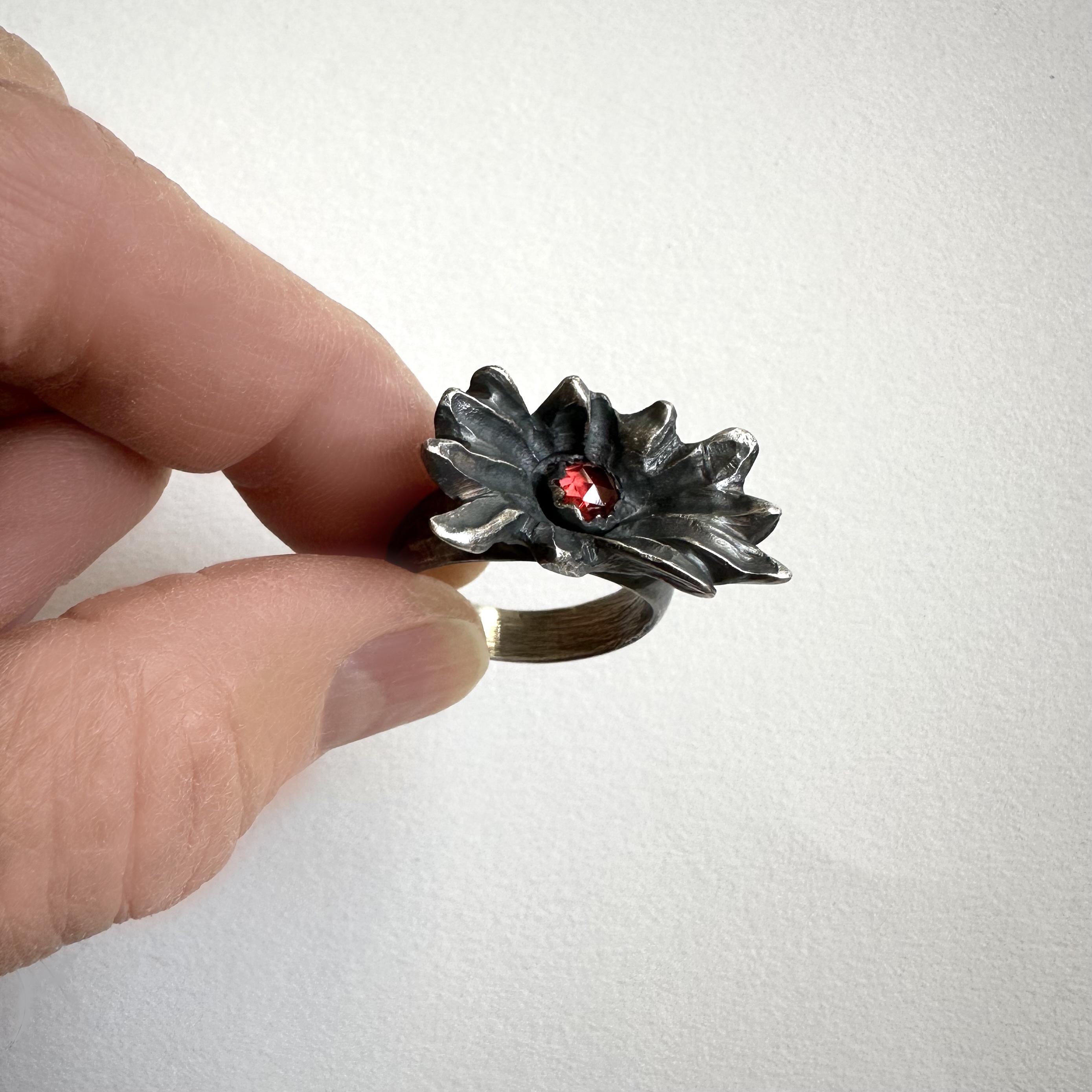 Weedflower Ring with Garnet, 2026 | Fabricated oxidized sterling silver with garnet; ring size 7.25