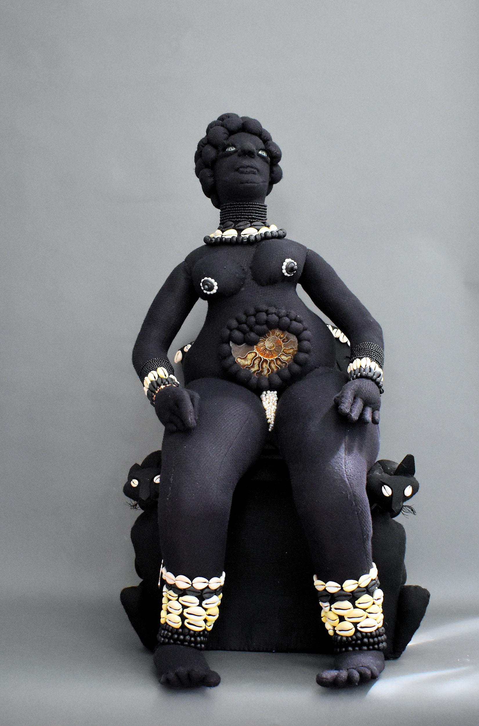 Mother | 2025, felt, cowries, wooden and glass beads, 110 million year old ammonite