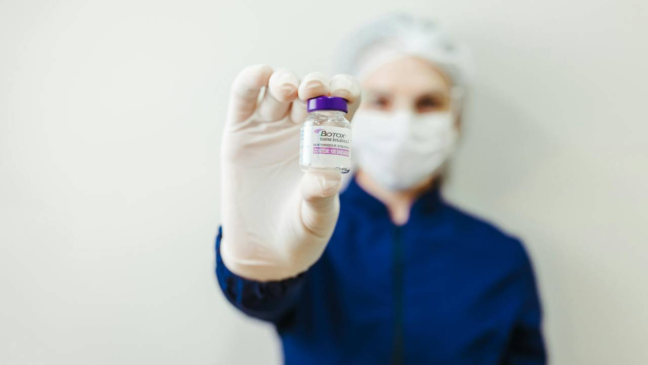 Picture of a woman holding a bottle of Botox. 
