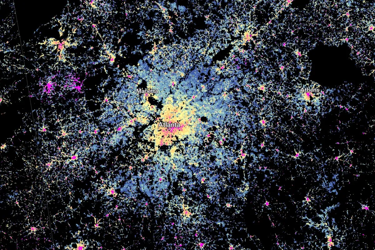 A thematic population density map of the Atlanta metropolitan area, using a color gradient from bright yellow and pink in high-density urban centers to blue in lower-density suburban areas.