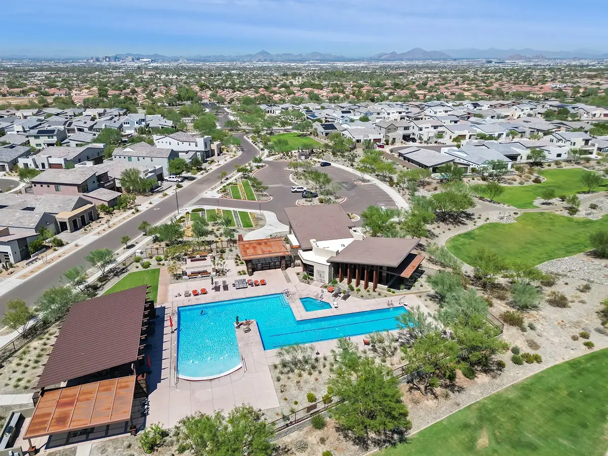 Aerial view of The Quarry community pool complex, clubhouse, surrounding homes, desert landscaping, and Phoenix city skyline