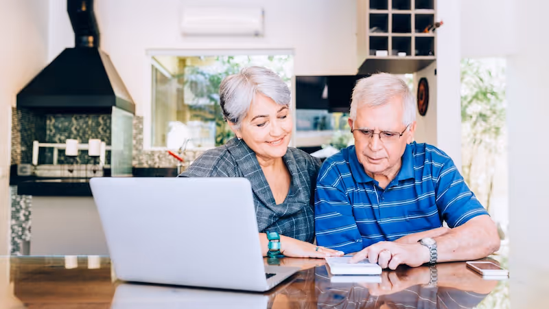Senior couple looking at their computer and calculations