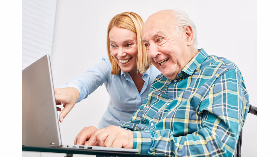 Senior man and young women looking at computer