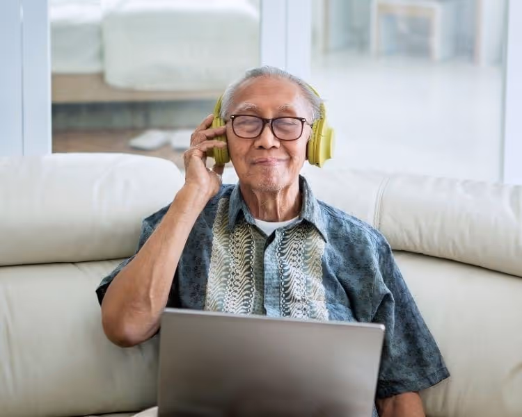 Senior man enjoying music through headphones