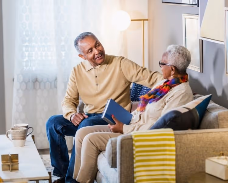 Senior couple enjoying a hot beverage on a couch together