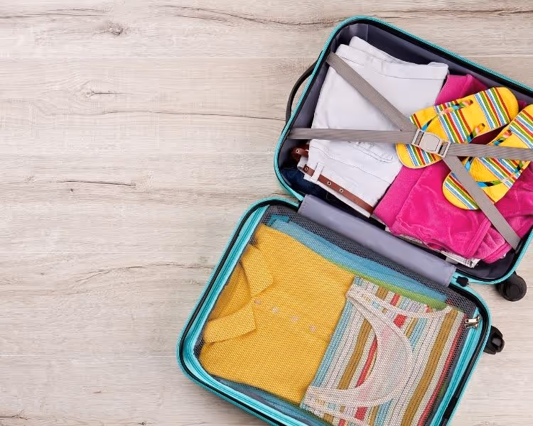 Open suitcase packed with clothes