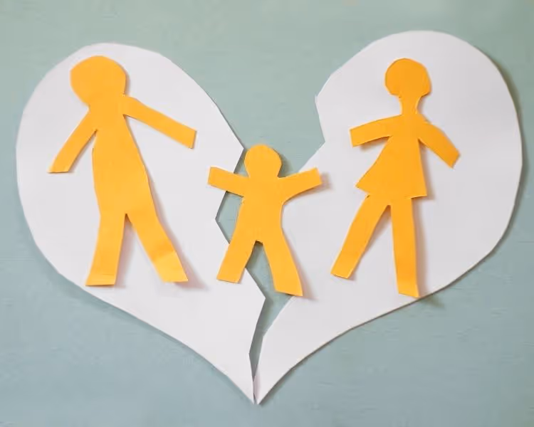 Paper heart torn apart with yellow stick figures