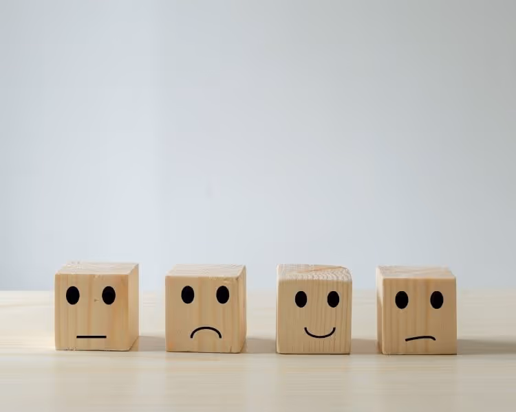 Four wood blocks with different emotion faces