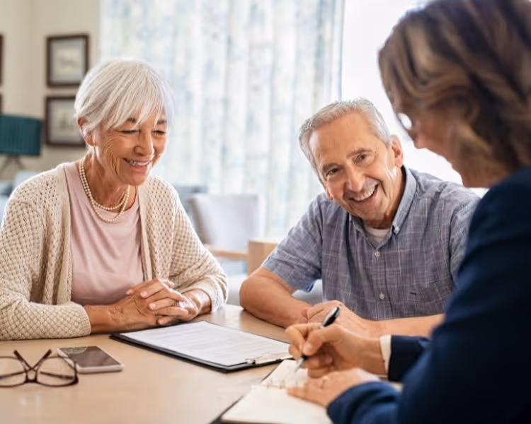 A senior couple sitting across a table from a consultant