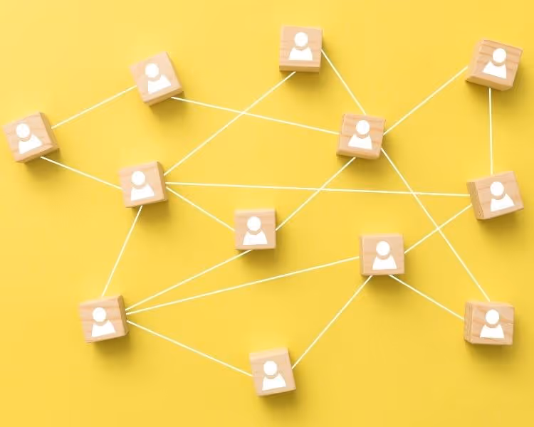 Yellow background with wooden people tied together by a string