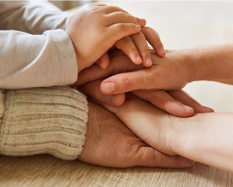 Three generations of hands stacked on top of eachother