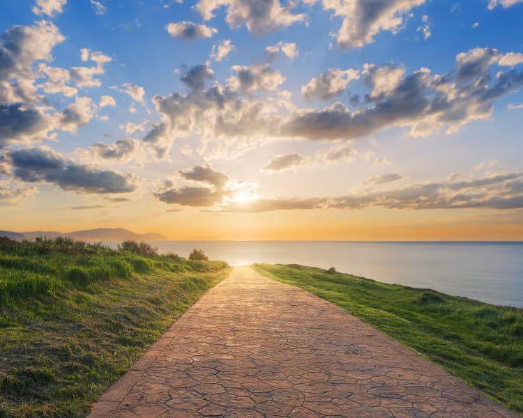 An oceanside path leading to the sunset