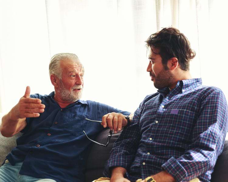 senior father and adult son discuss eldercare