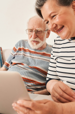 Un enfant souriant assis entre deux hommes adultes, regardant l'un d'eux avec affection.
