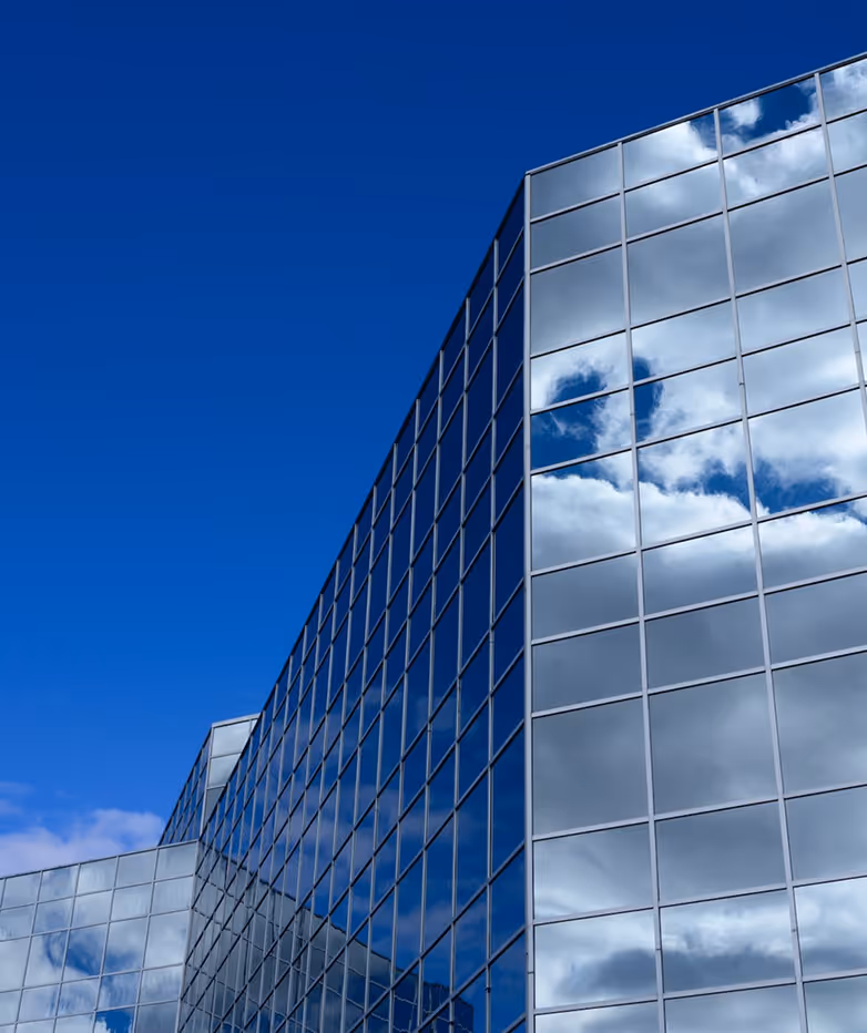 Façade d'un bâtiment bleu avec des balcons symétriques équipés de garde-corps en verre.