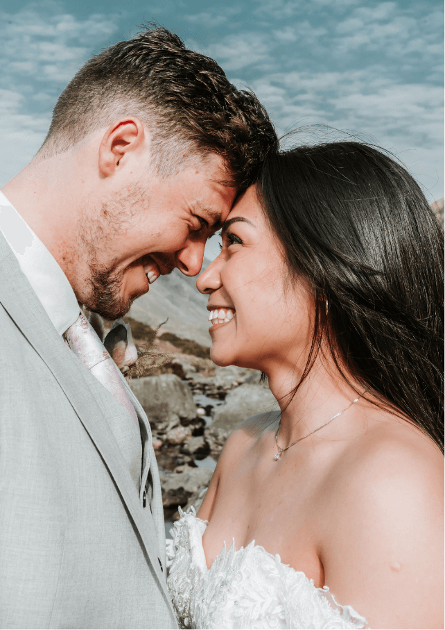 A photo of a newly wed couple smiling into each other's faces with a gorgeous blue sky overhead. Gemma Randall Photography ©
